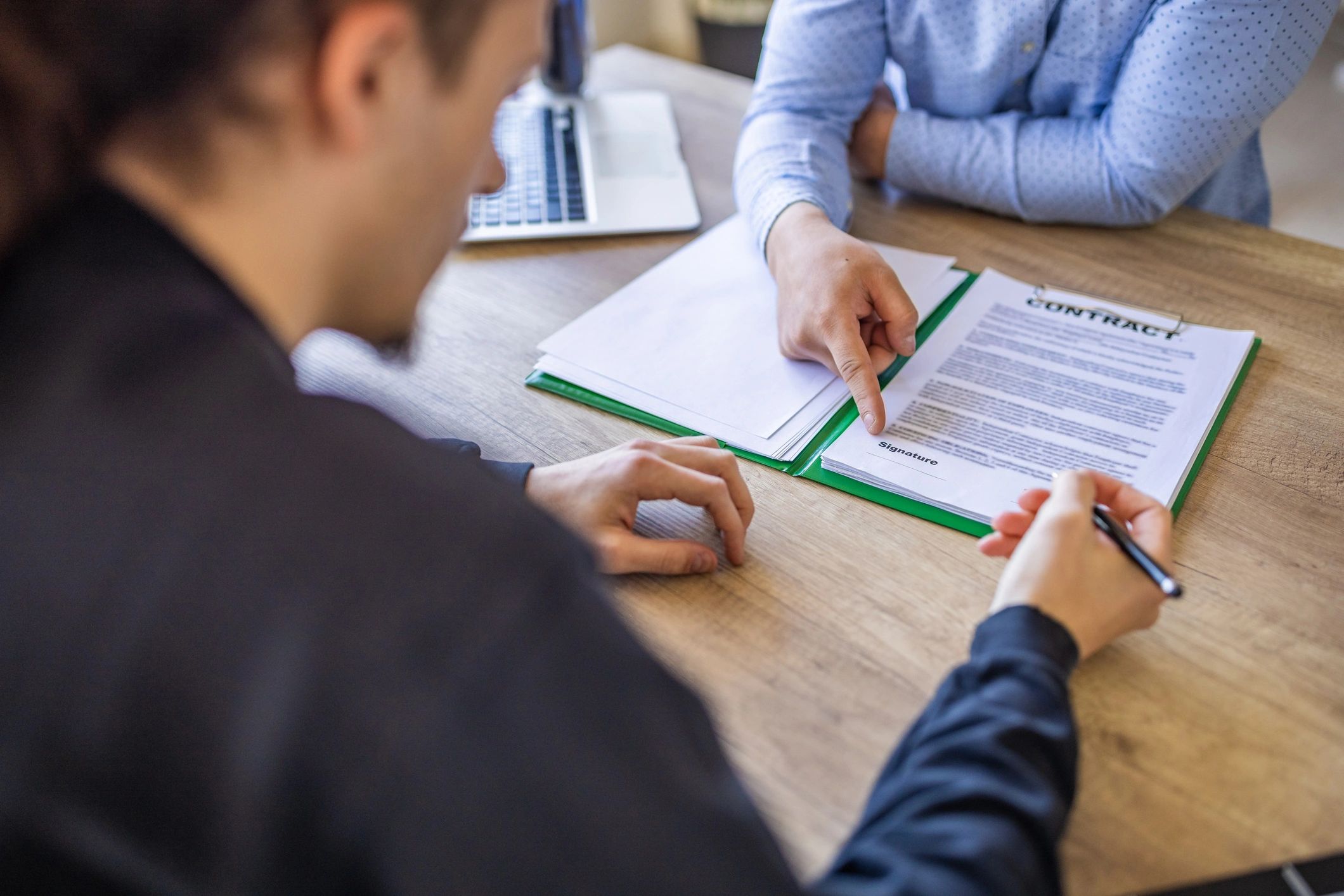 Borrower signing documents during a mortgage consultation