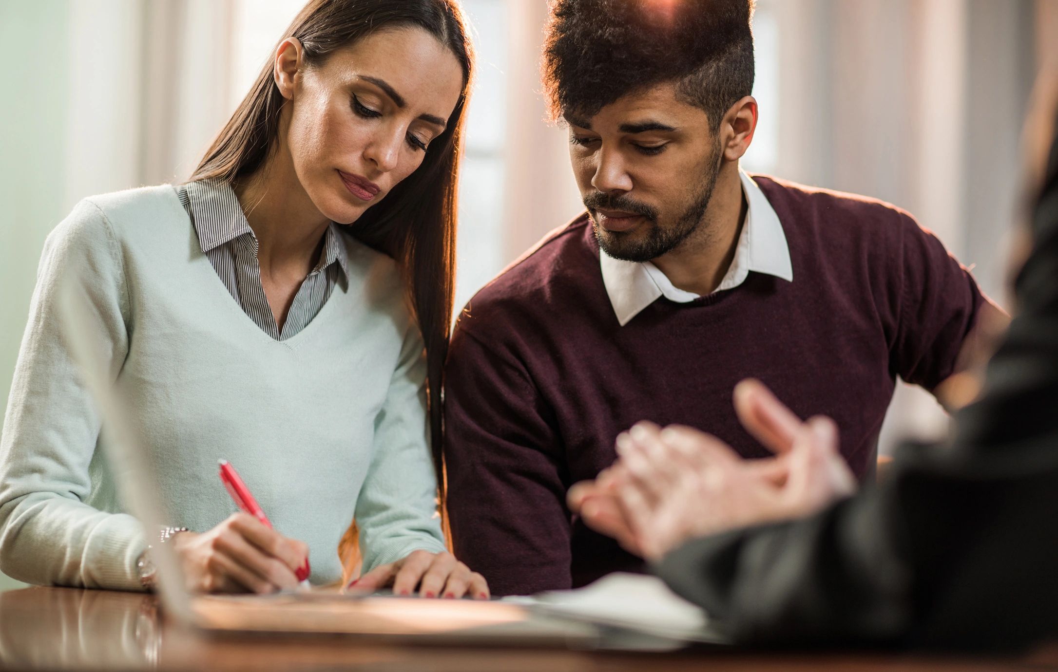Homebuyers signing documents with an advisor